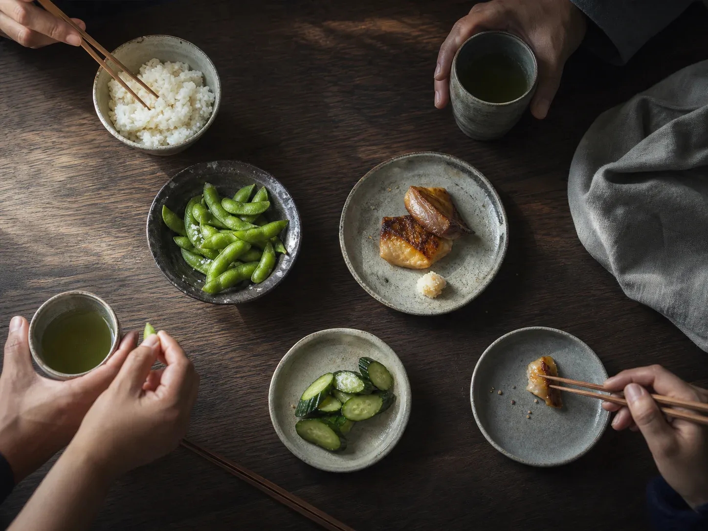 Small plates, rice and tea shared around a dark oak table