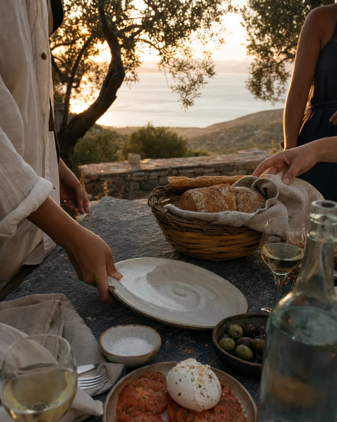 A sunset table being prepared among olive trees.