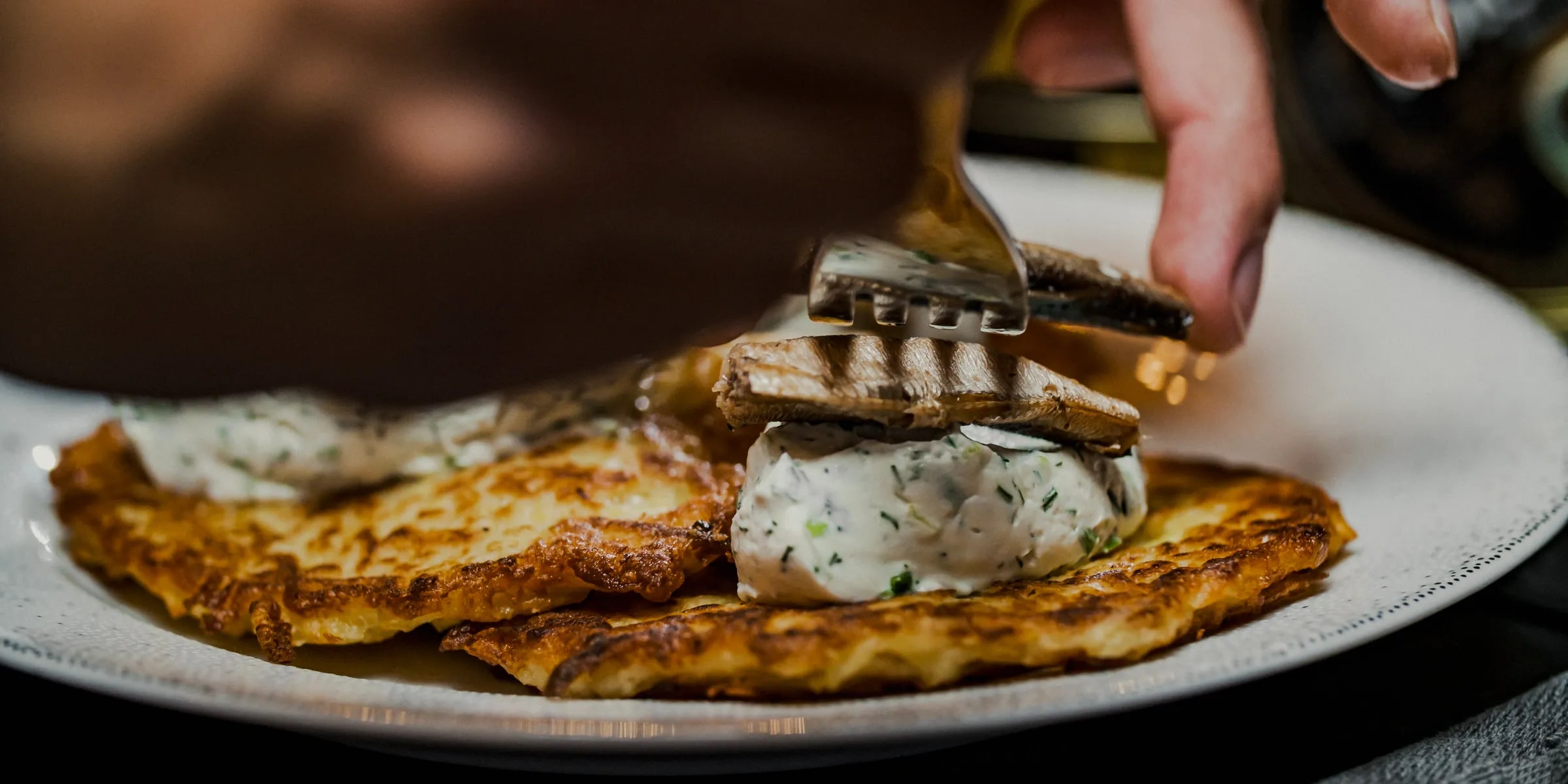 Potato pancakes, fresh cheese cream and smoked sprats.