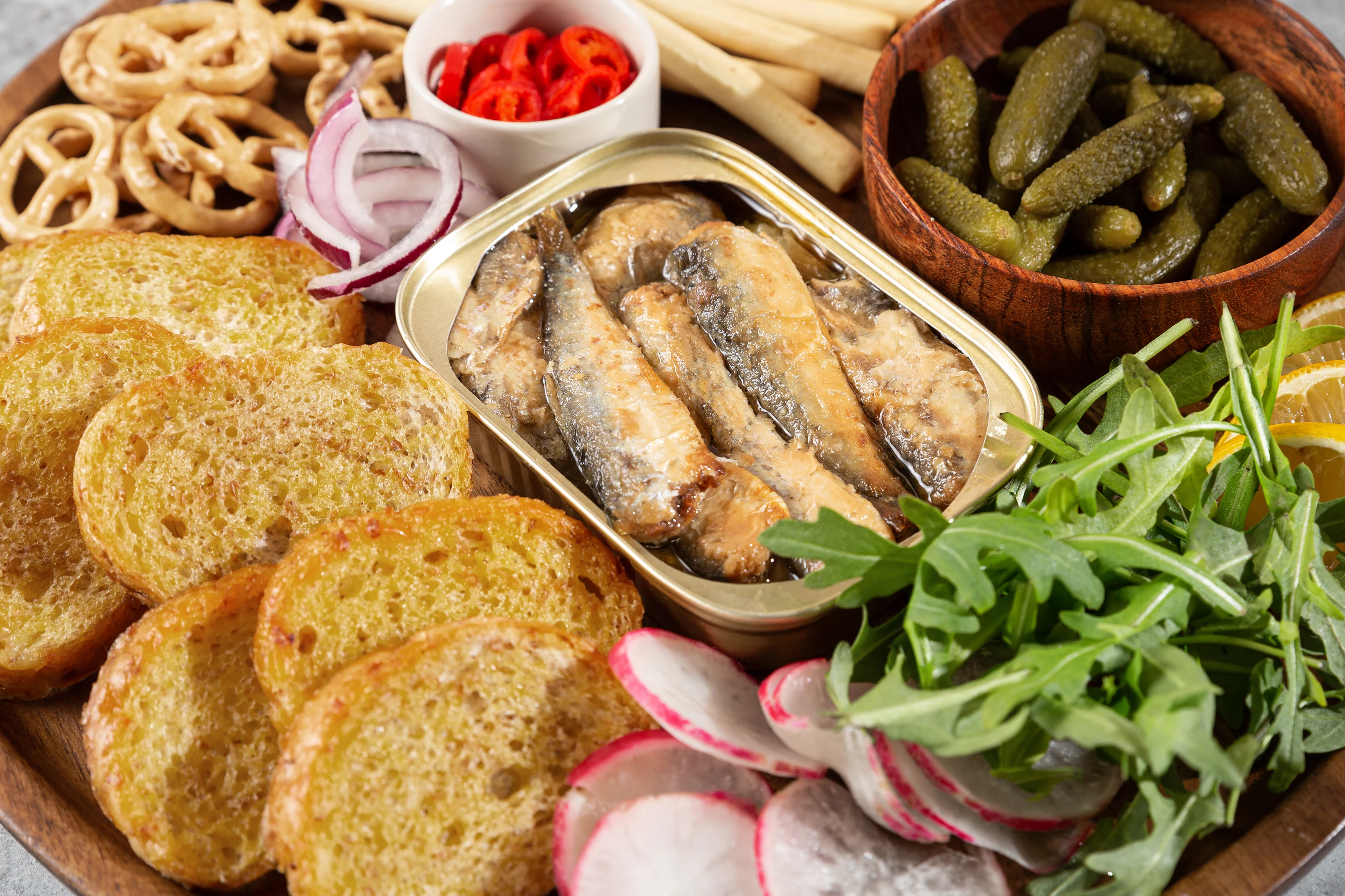 Open smoked sprats served with toasted bread, vegetables and herbs