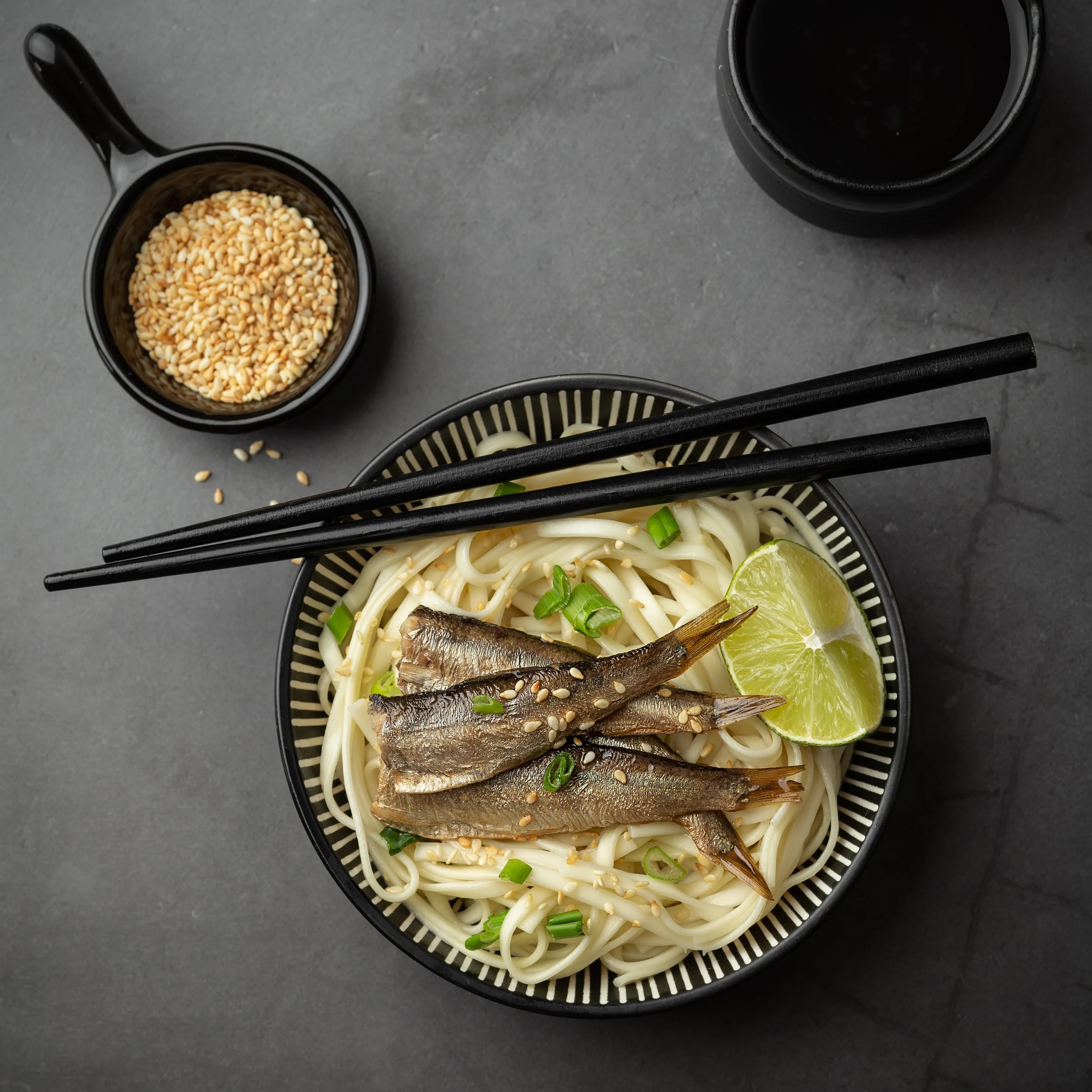 Smoked sprats served with noodles, sesame, lime and spring onion in an Asian-inspired dish