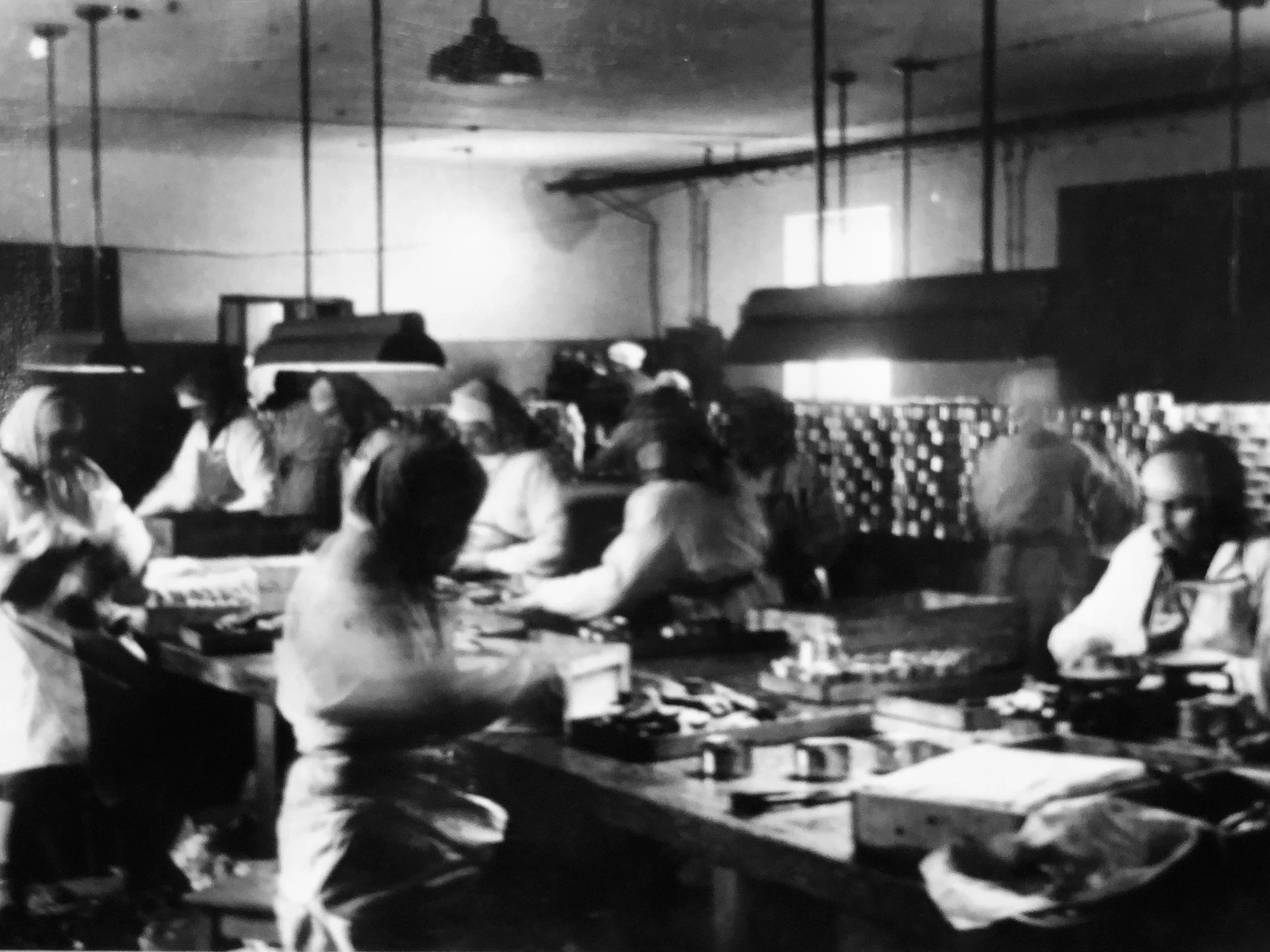 Historic Engure production room with workers gathered around preparation tables