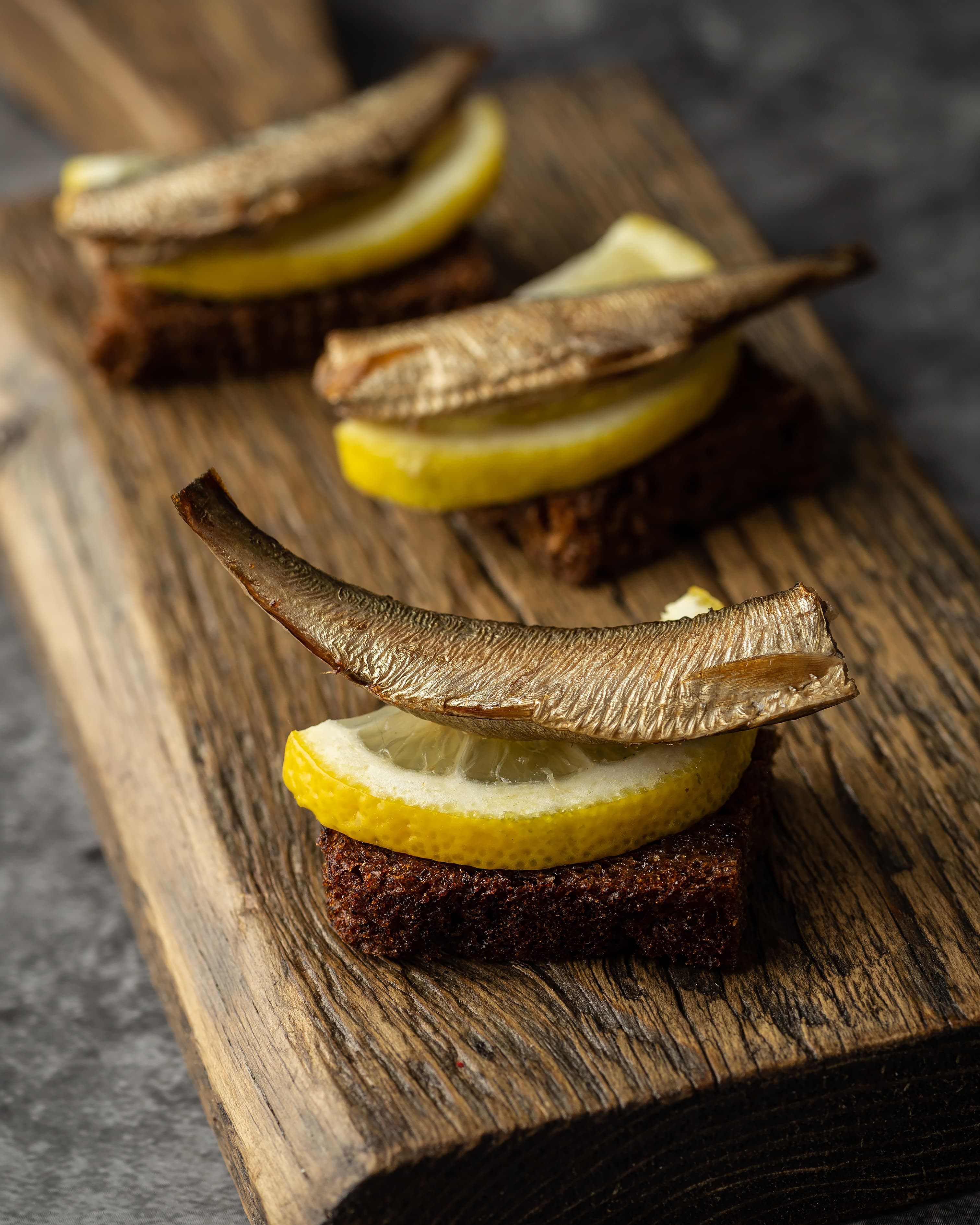 Tradicionāli kūpinātas šprotes uz rupjmaizes ar citronu